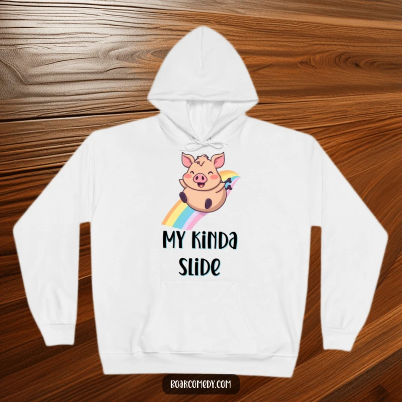 Funny hoodie depicting a plump boar character joyfully sliding down a bright rainbow, ears flapping, offering cozy humor.
